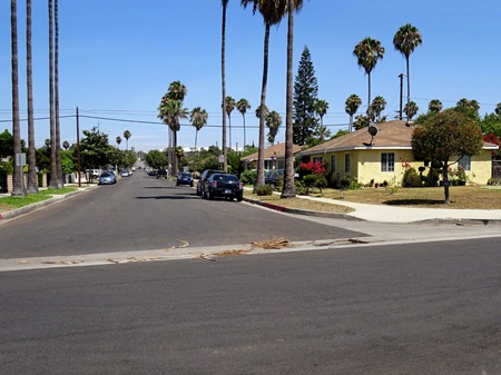 Carson CA Wall St Looking down Wall Street residential neighborhood in Carson, palm trees line the street and surrounding homes