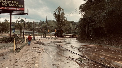 A washed out street with downed power lines in Asheville NC