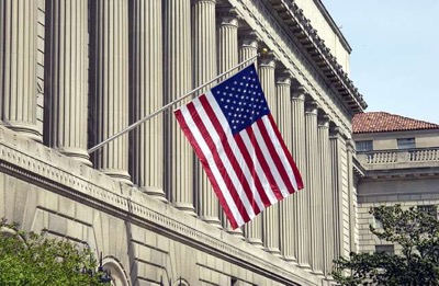 Commerce Dept bldg US Commerce Department building with US flag hanging in front of pillars
