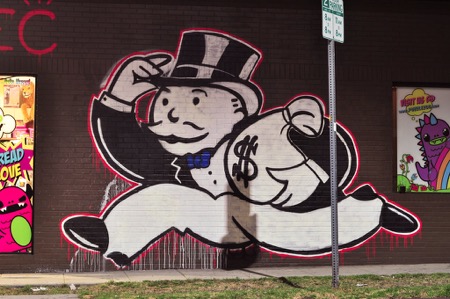 Monopoly Man Street Art Street art on side of building depicts Mr. Monopoly running off with a bag of cash