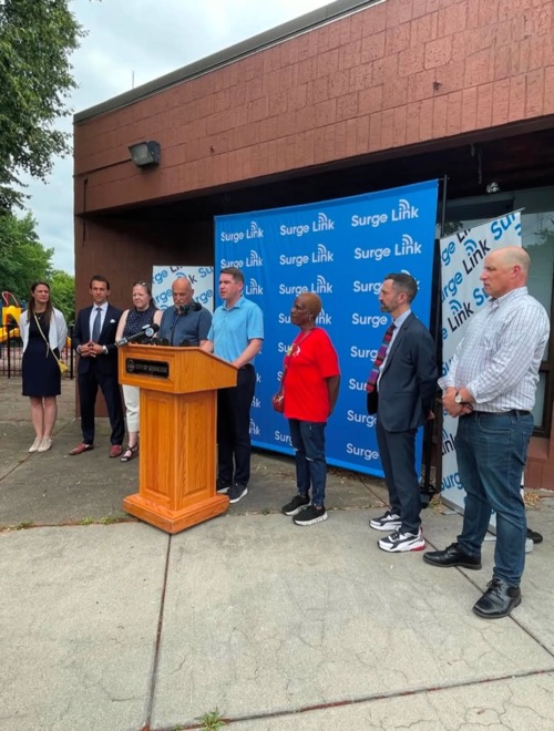 Syracuse Mayor Ben Walsh speaks at podium in front of community center at Surge Link launch party