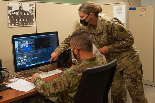 Veterans at computer  Two veterans in uniform work at computer station