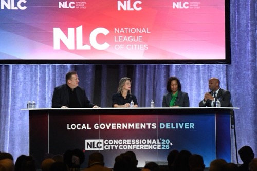 Four local leaders sit at table on stage at National League of Cities 2026 Conference