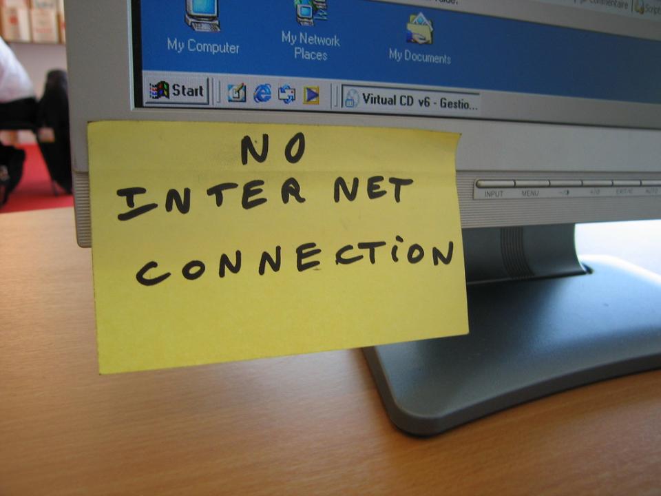 A computer screen has a sticky note attached to it that reads "No Internet Connection"