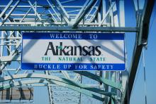 Welcome to Arkansas sign hangs over bridge