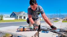 A fiber technician lays bare the insides of a fiber splice case in a residential neighborhood