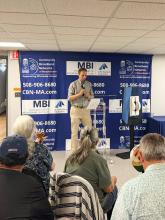 An MBI officials stands with microphone in front of Southbridge residents